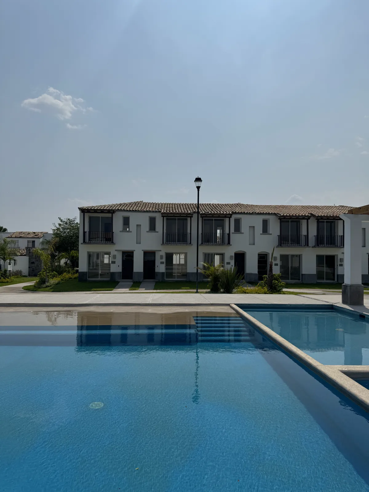 Alberca climatizada con casas al fondo